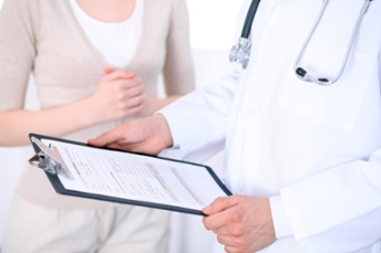 doctor holding clipboard with patient