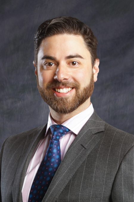 Head shot of Dr. Weitz, who is wearing a gray suit, white and pink shirt, and blue and pink tie