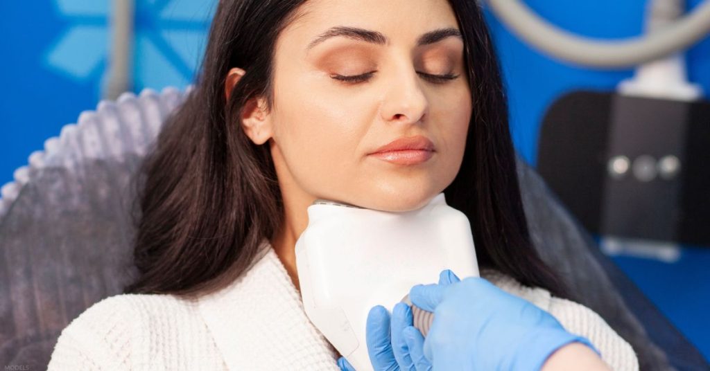 Woman receiving a CoolSculpting treatment to her chin (model)