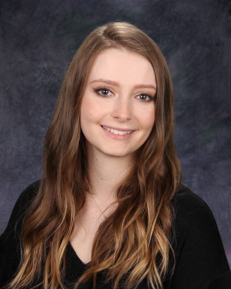 Head shot of licensed aesthetician Carly White as she smiles at the camera.