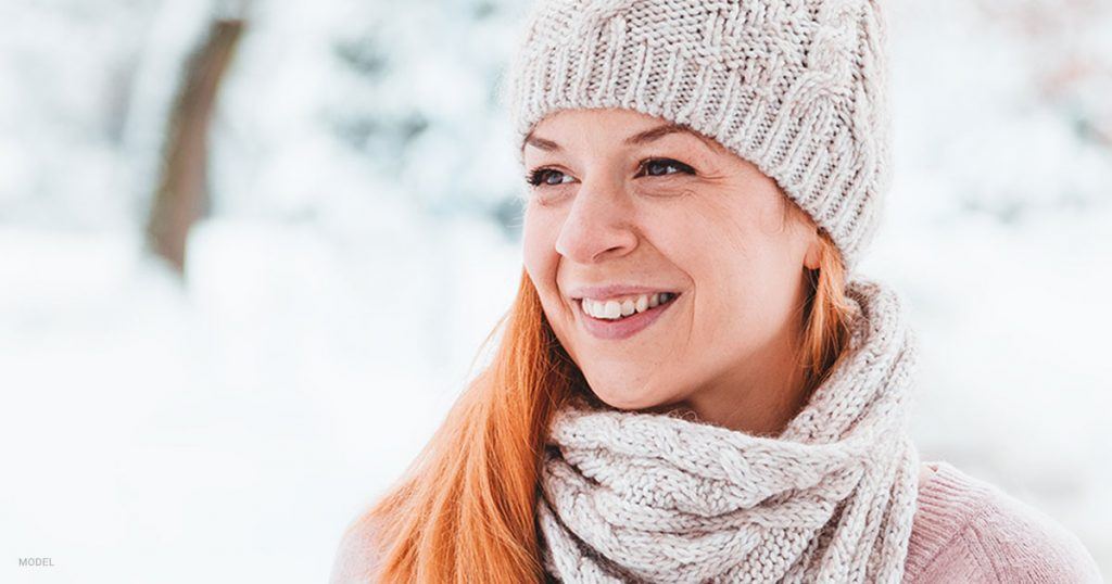 Woman in warm clothes embracing the winter weather