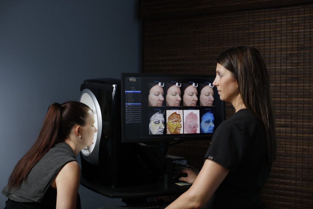Provider using Visia complexion analysis with patient. 