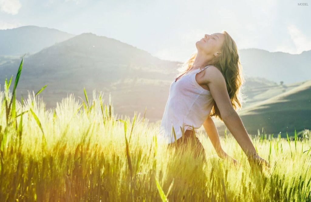 Woman (model) relaxing outside in a natural setting.