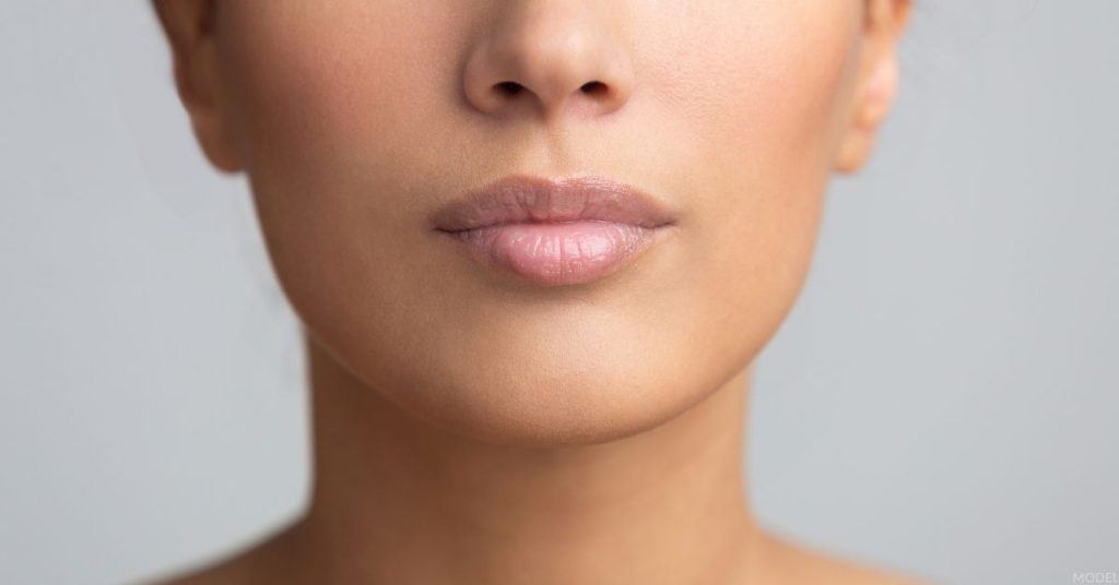 The lower half of a woman's face, featuring her plump lips (model)