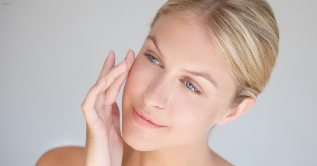 Woman showing results after dermal filler treatment (model)